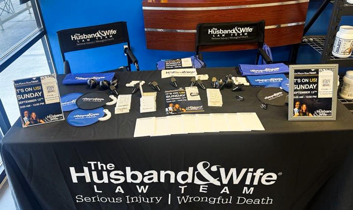 A Husband & Wife Law Team outreach table at iLL Chino Meal Service welcomes community members with information, giveaways, and resources during a HEART event.