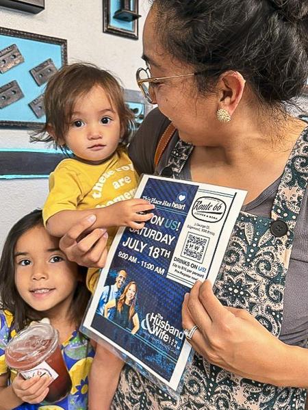 A mother and her children enjoy a visit to Route 66 Coffee & Boba Co., with a Husband & Wife Law Team flyer in hand and smiles all around.