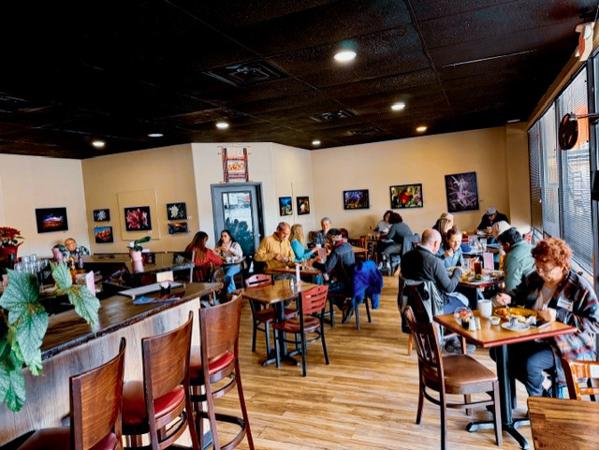 Sagches' cafe with patrons seated at wooden tables and the bar, enjoying coffee