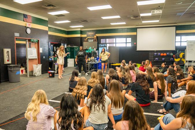 Students sit attentively in class while Coach Bright receives The Husband & Wife Law Team’s Teacher Appreciation Award, celebrating his impact both in and beyond the classroom.