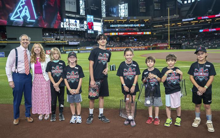 Mark & Alexis Breyer celebrate with the Husband & Wife Law Team’s “Kids Take the Field” winners at the ballpark.
